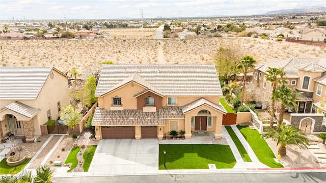 view of front of home featuring stucco siding, driveway, an attached garage, and fence