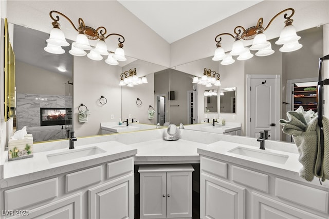 bathroom with lofted ceiling, double vanity, a chandelier, and a sink