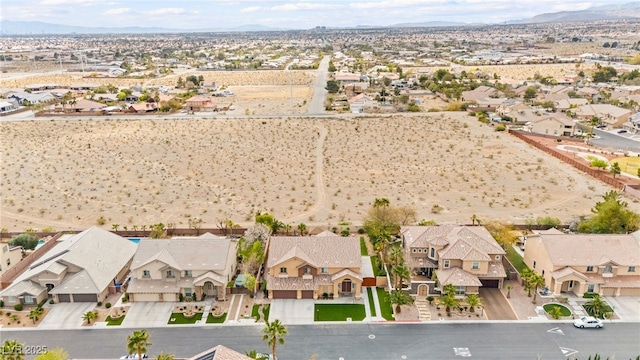 birds eye view of property featuring view of desert, a mountain view, and a residential view