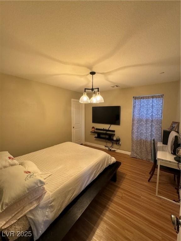 bedroom featuring wood finished floors and a textured ceiling