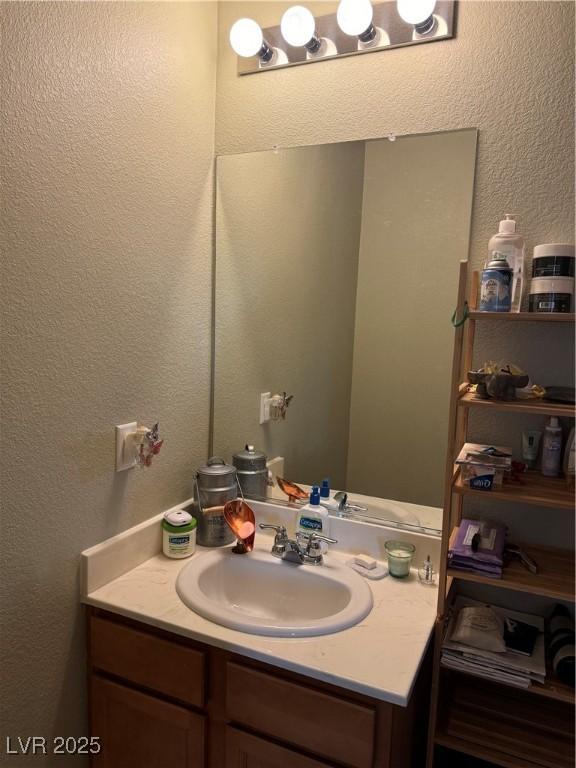 bathroom with vanity and a textured wall