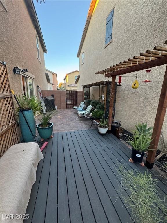 wooden terrace featuring a patio area and fence