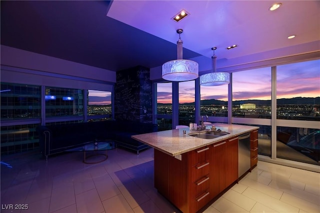 kitchen with a sink, light stone countertops, decorative light fixtures, modern cabinets, and a kitchen island with sink