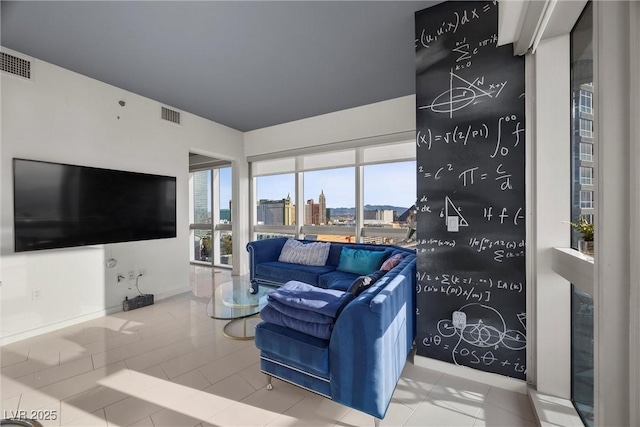 tiled living area featuring a city view, baseboards, and visible vents