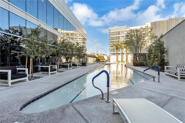 community pool with a patio and fence