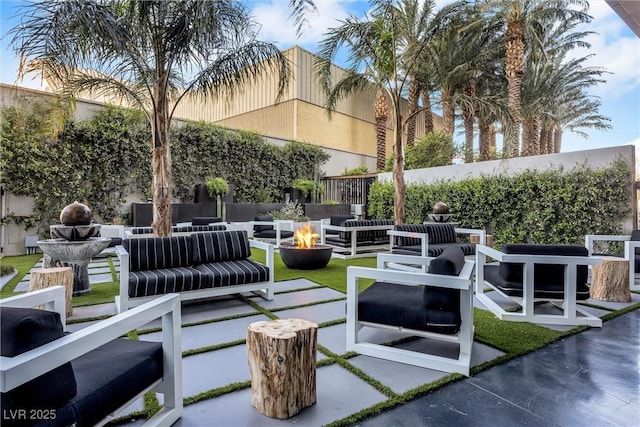 view of patio / terrace featuring an outdoor living space with a fire pit and fence