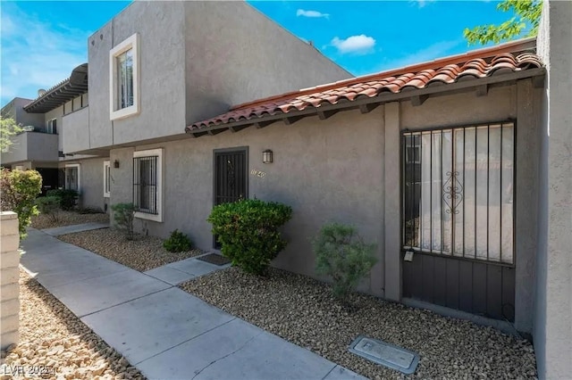 view of home's exterior with a tile roof and stucco siding