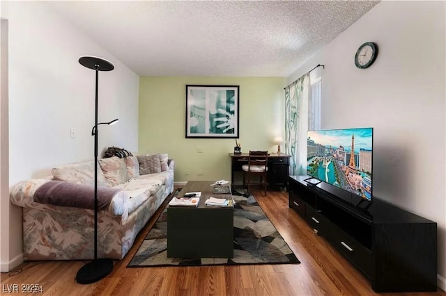 living area with a textured ceiling and wood finished floors