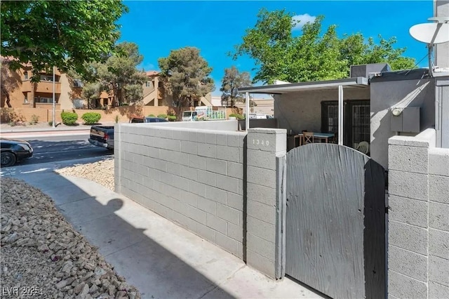 view of side of property with a gate, fence, and a residential view