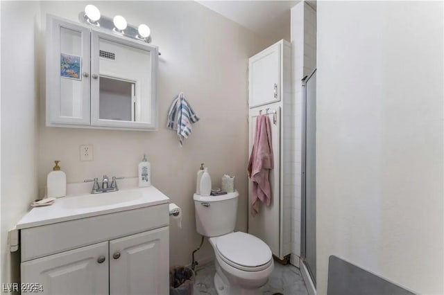 bathroom with a shower stall, toilet, and vanity