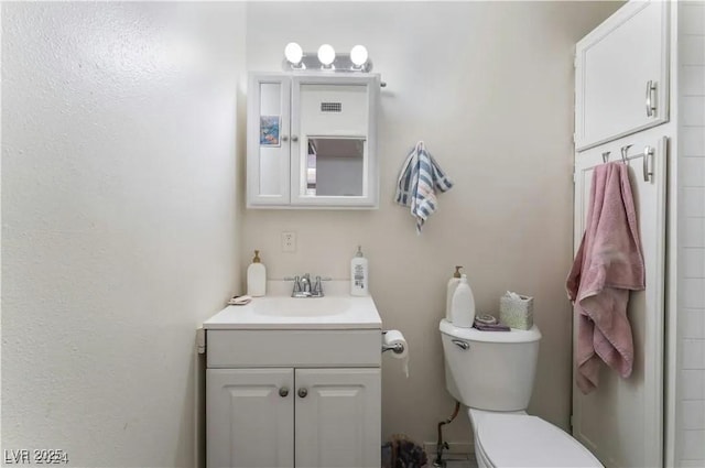 bathroom featuring toilet and vanity