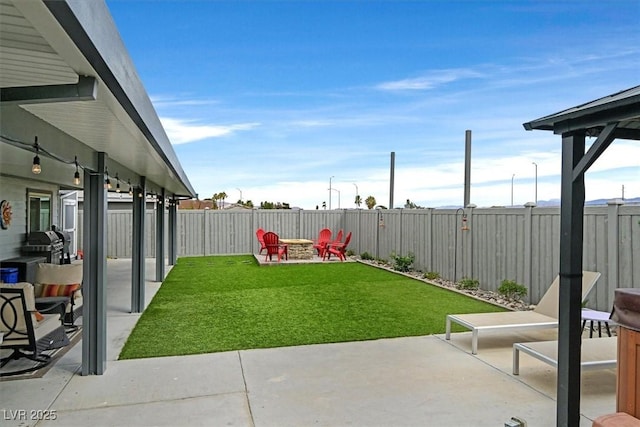 view of yard featuring a fire pit, a fenced backyard, and a patio area