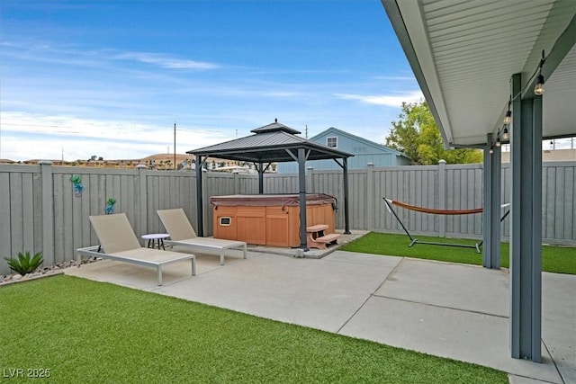 view of patio / terrace with a gazebo, a hot tub, and a fenced backyard