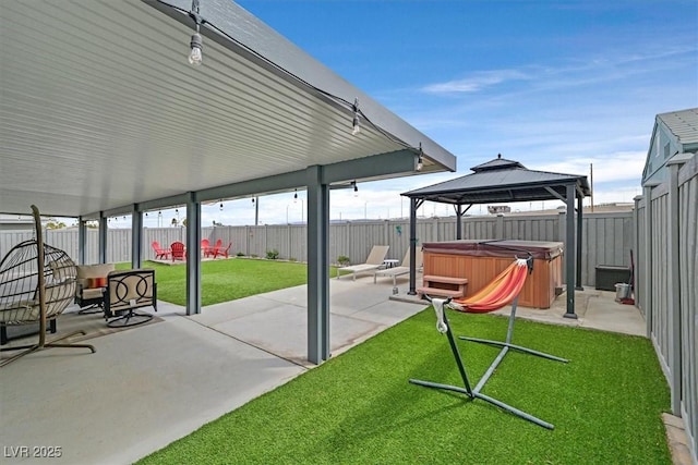 view of patio featuring a gazebo, a fenced backyard, and a hot tub