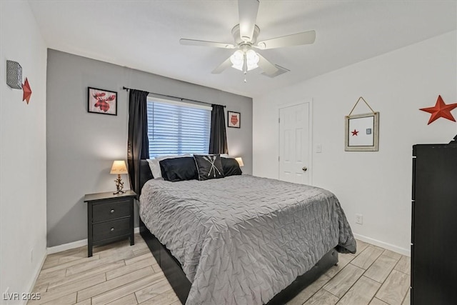 bedroom featuring baseboards, wood finish floors, and a ceiling fan