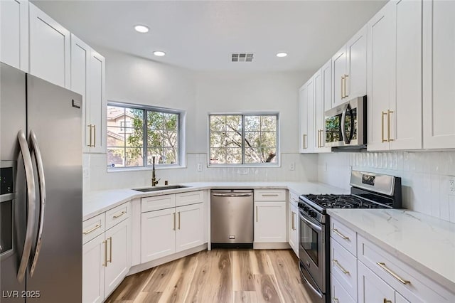 kitchen featuring a sink, stainless steel appliances, plenty of natural light, and visible vents