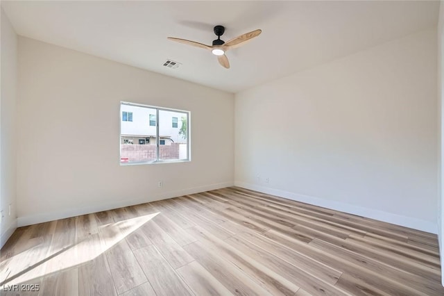 unfurnished room featuring light wood finished floors, visible vents, a ceiling fan, and baseboards