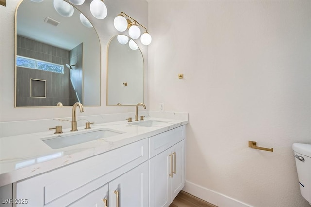 bathroom with a sink, visible vents, baseboards, and toilet