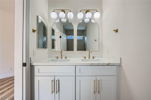 full bathroom with a sink, wood finished floors, and double vanity