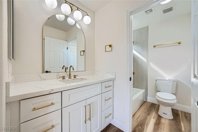 full bathroom featuring visible vents, baseboards, toilet, wood finished floors, and vanity