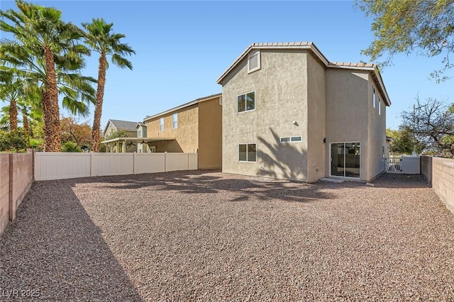 back of property with stucco siding and a fenced backyard