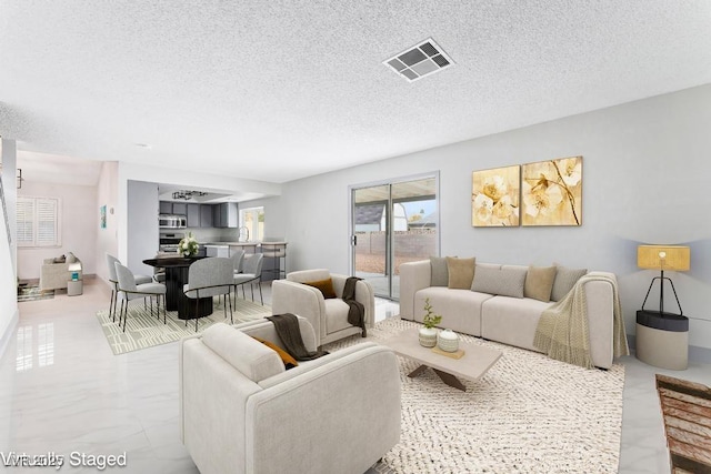 living room with visible vents and a textured ceiling