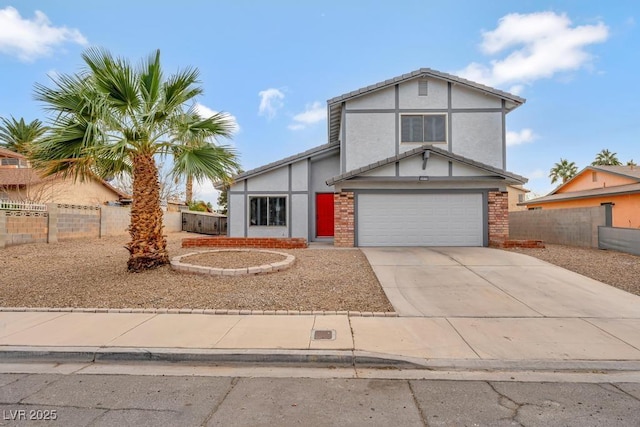 view of front facade with a garage, stucco siding, driveway, and fence