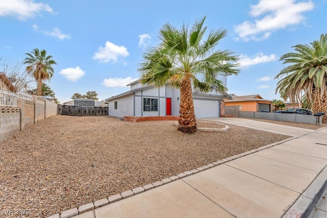 view of front of property featuring concrete driveway, an attached garage, fence, and stucco siding