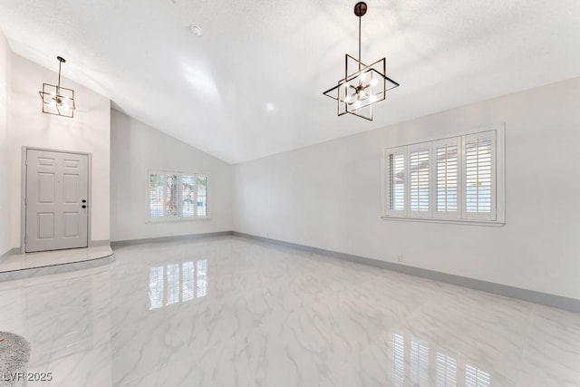 interior space featuring vaulted ceiling, a notable chandelier, baseboards, and marble finish floor