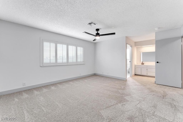 unfurnished room featuring baseboards, visible vents, ceiling fan, a textured ceiling, and light colored carpet