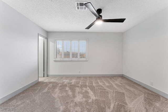 carpeted spare room featuring visible vents, a textured ceiling, baseboards, and ceiling fan