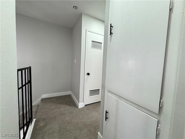 hallway featuring visible vents, baseboards, and carpet