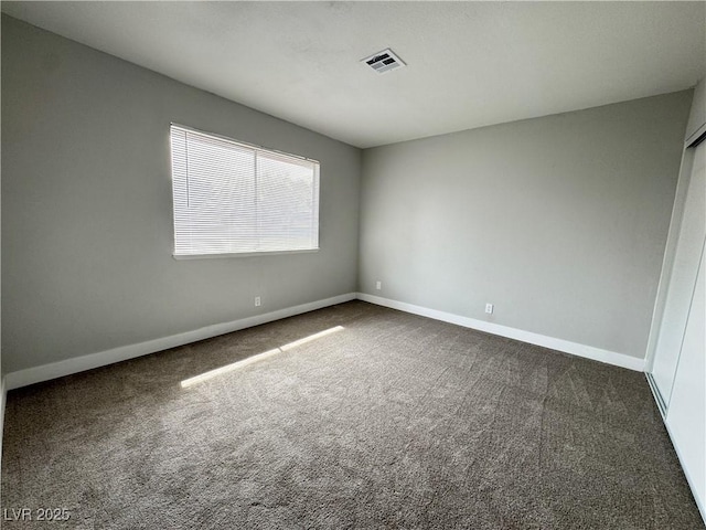 spare room with visible vents, baseboards, and carpet