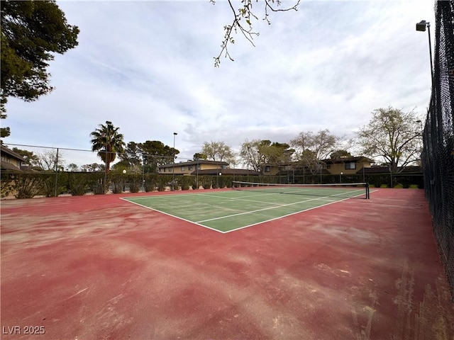 view of tennis court featuring fence