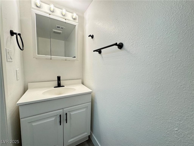 bathroom featuring vanity and a textured wall