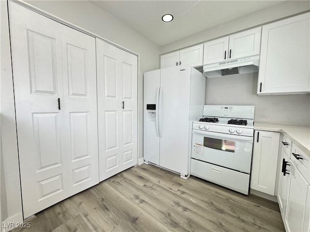 kitchen featuring under cabinet range hood, light countertops, light wood-style floors, white appliances, and white cabinetry