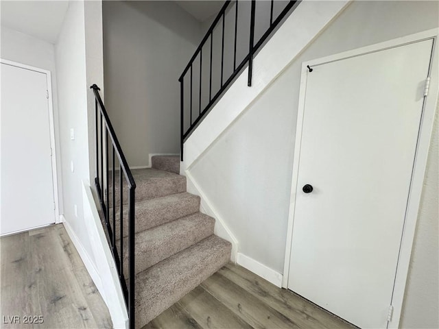 stairway with baseboards and wood finished floors