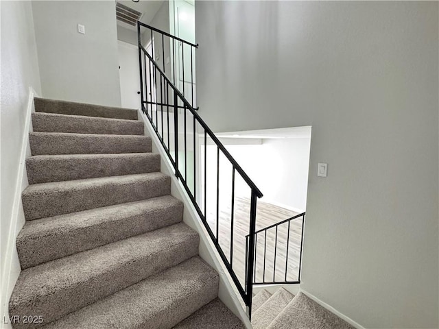 stairs with a high ceiling and carpet flooring