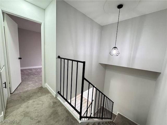 stairway with baseboards and carpet floors