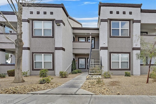 view of front of property featuring stairs and stucco siding