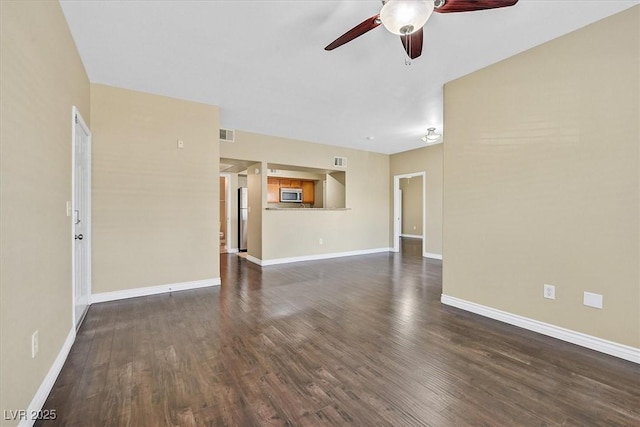 interior space with dark wood-style floors, baseboards, and a ceiling fan