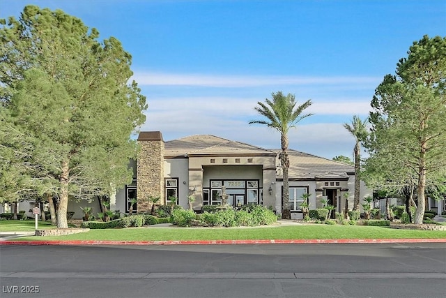 view of front of home featuring stucco siding and a front lawn