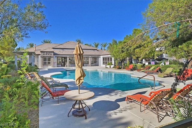 pool with a patio and fence