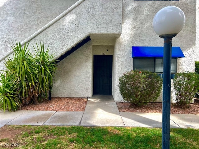 view of exterior entry featuring stucco siding