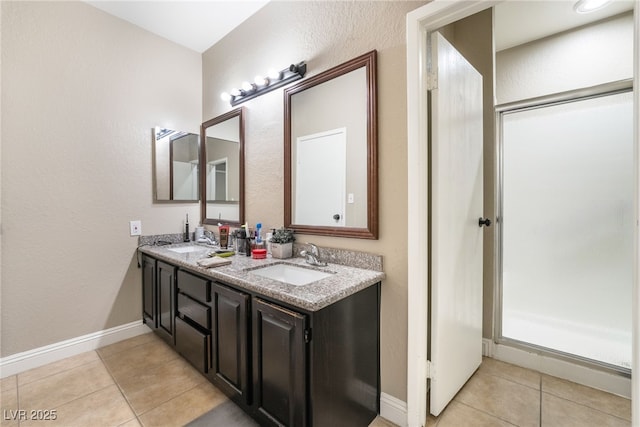 bathroom with tile patterned floors, baseboards, and a sink