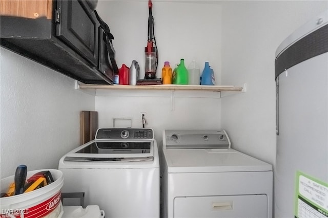 washroom featuring cabinet space, independent washer and dryer, and water heater