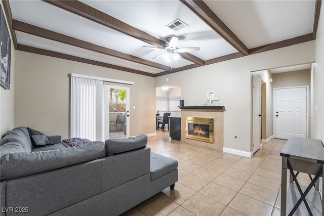 living room featuring visible vents, a tiled fireplace, beam ceiling, light tile patterned floors, and a ceiling fan