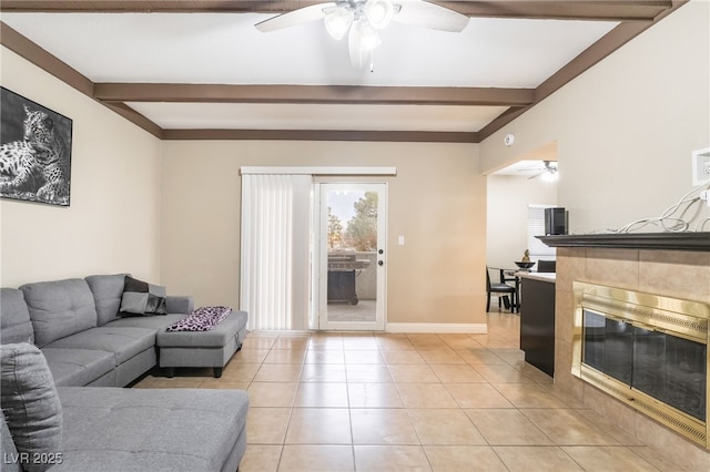 living area featuring beam ceiling, light tile patterned floors, and ceiling fan