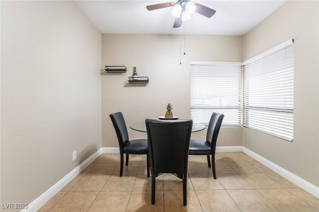 dining area with light tile patterned floors, baseboards, and a ceiling fan