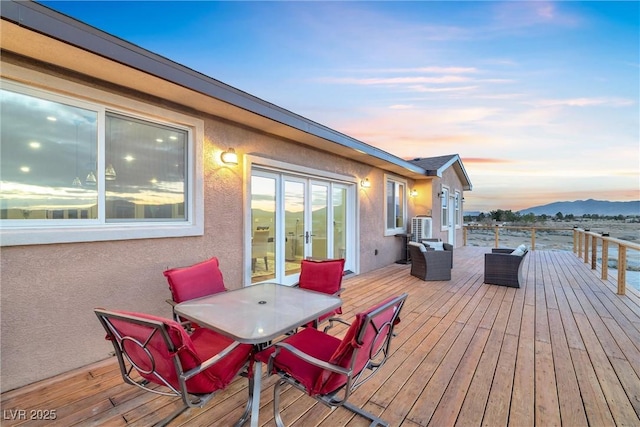 deck at dusk featuring french doors and a mountain view